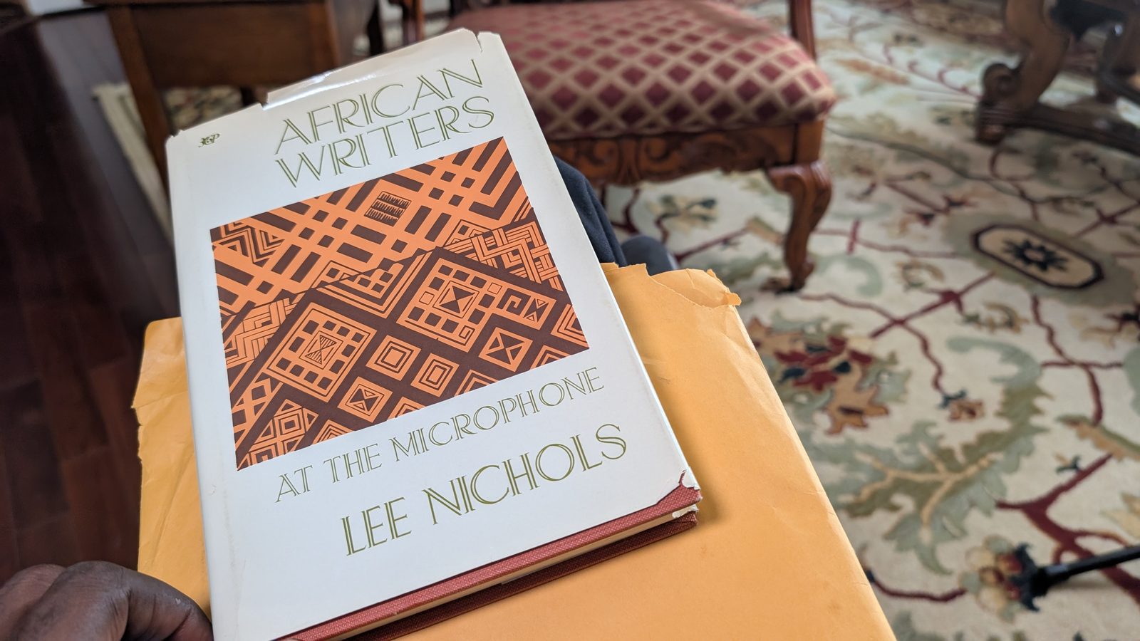 A copy of African Writers at the Microphone by Lee Nichols held above its envelope